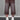 Back view of a model wearing brown wide-leg knit shorts with faded panels, raw hems, and two back pockets.