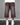 Back view of a model wearing brown wide-leg knit shorts with faded panels, raw hems, and two back pockets.