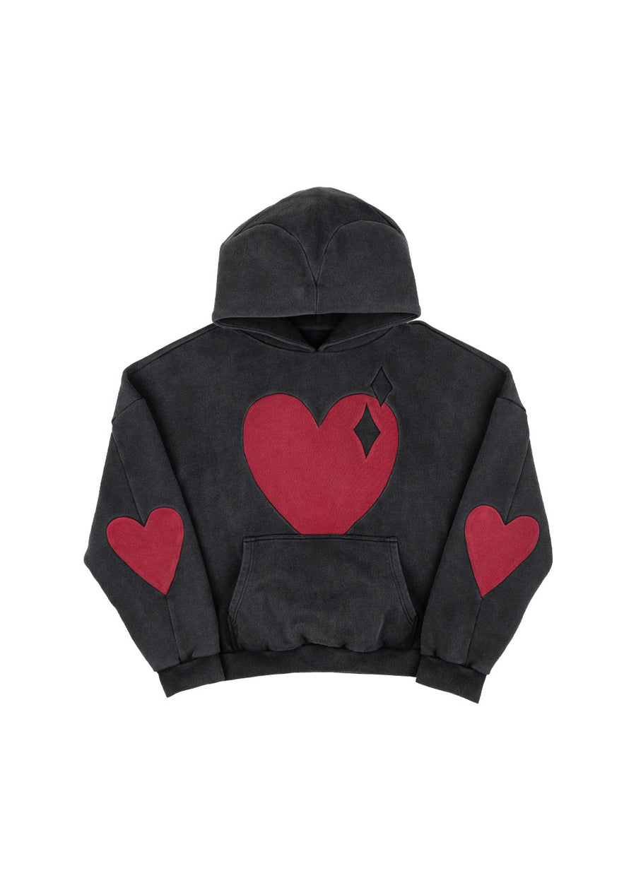 Washed black pullover hoodie with red hearts on the chest and sleeves and a kangaroo pocket, laid flat on white.