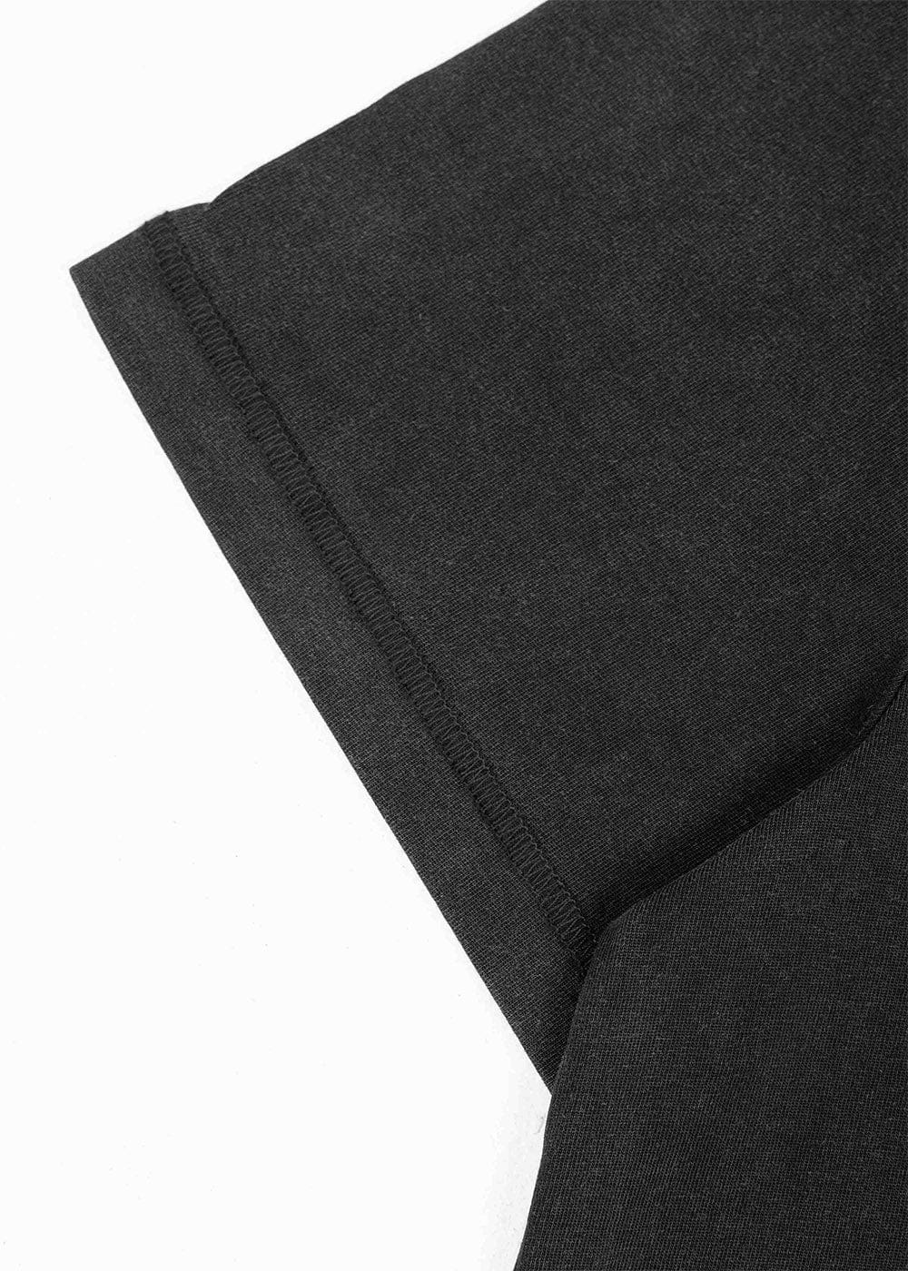 Close-up of a black knit T-shirt sleeve with a stitched hem on a white background.