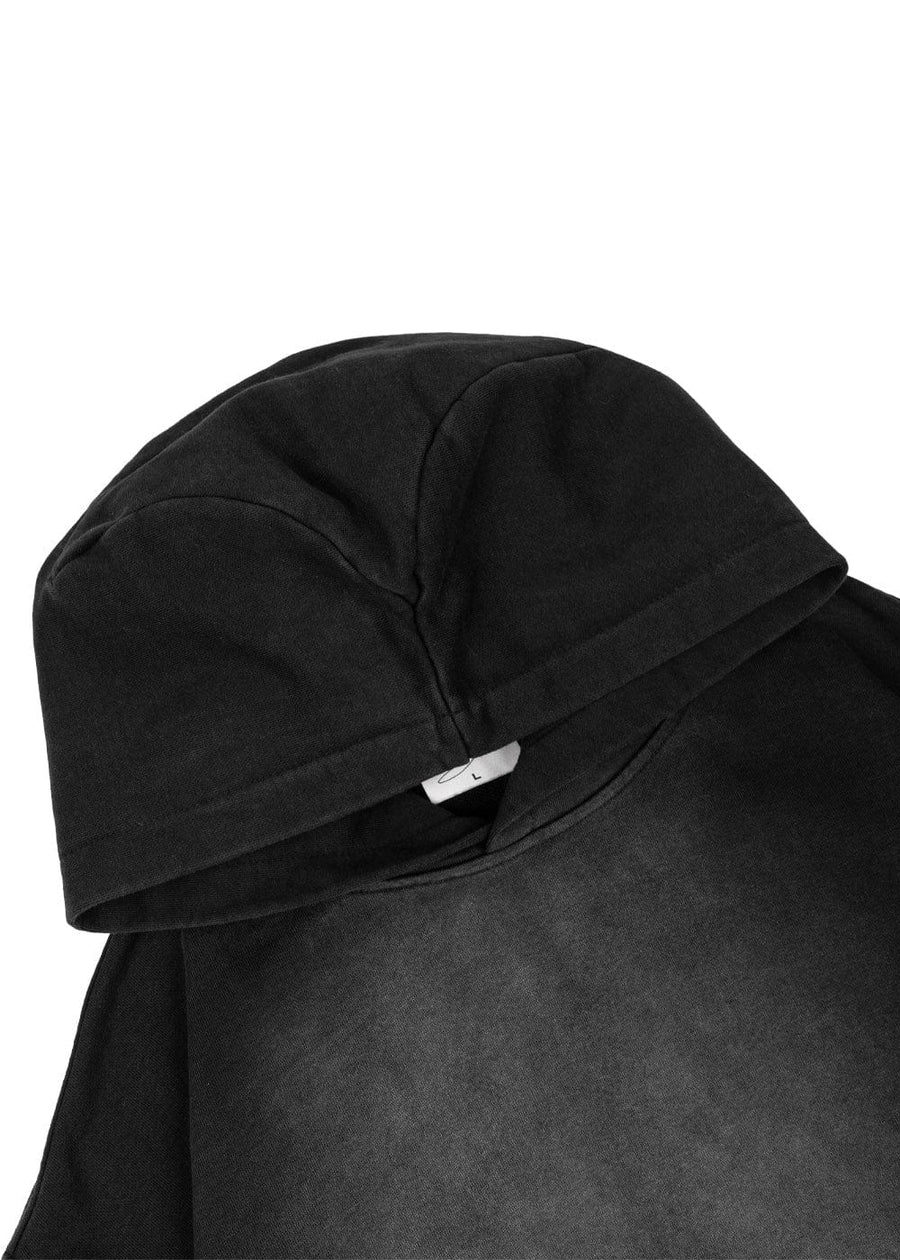 Close-up of a black knit hoodie with a paneled hood and visible stitching on a white background.