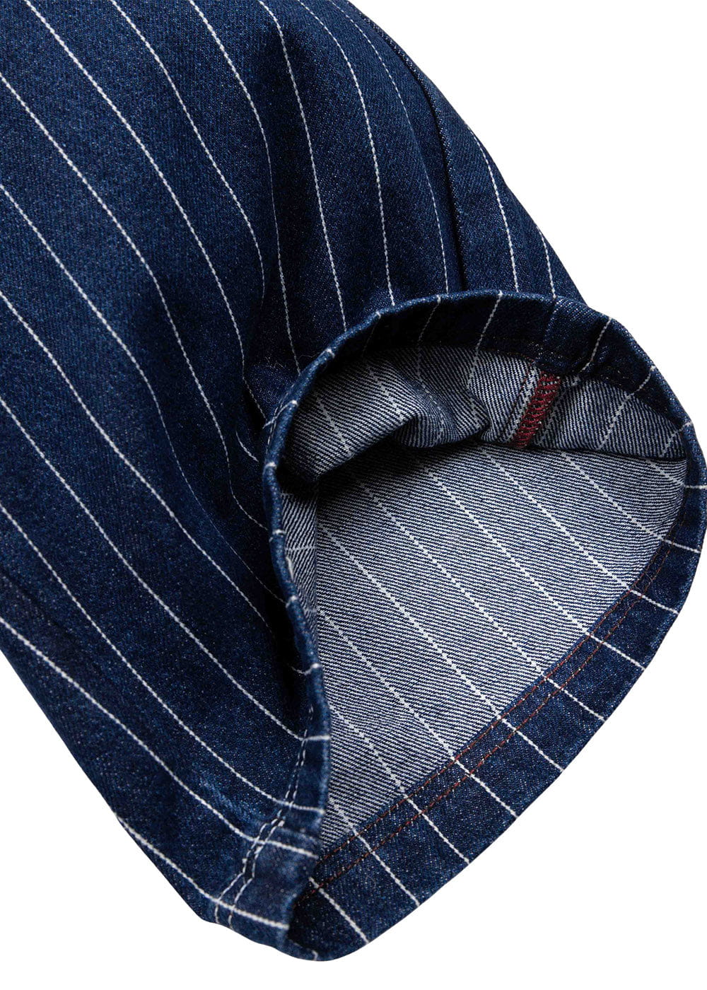 Close-up of a navy denim garment with white pinstripes and a folded hem exposing the lighter reverse and red stitching.