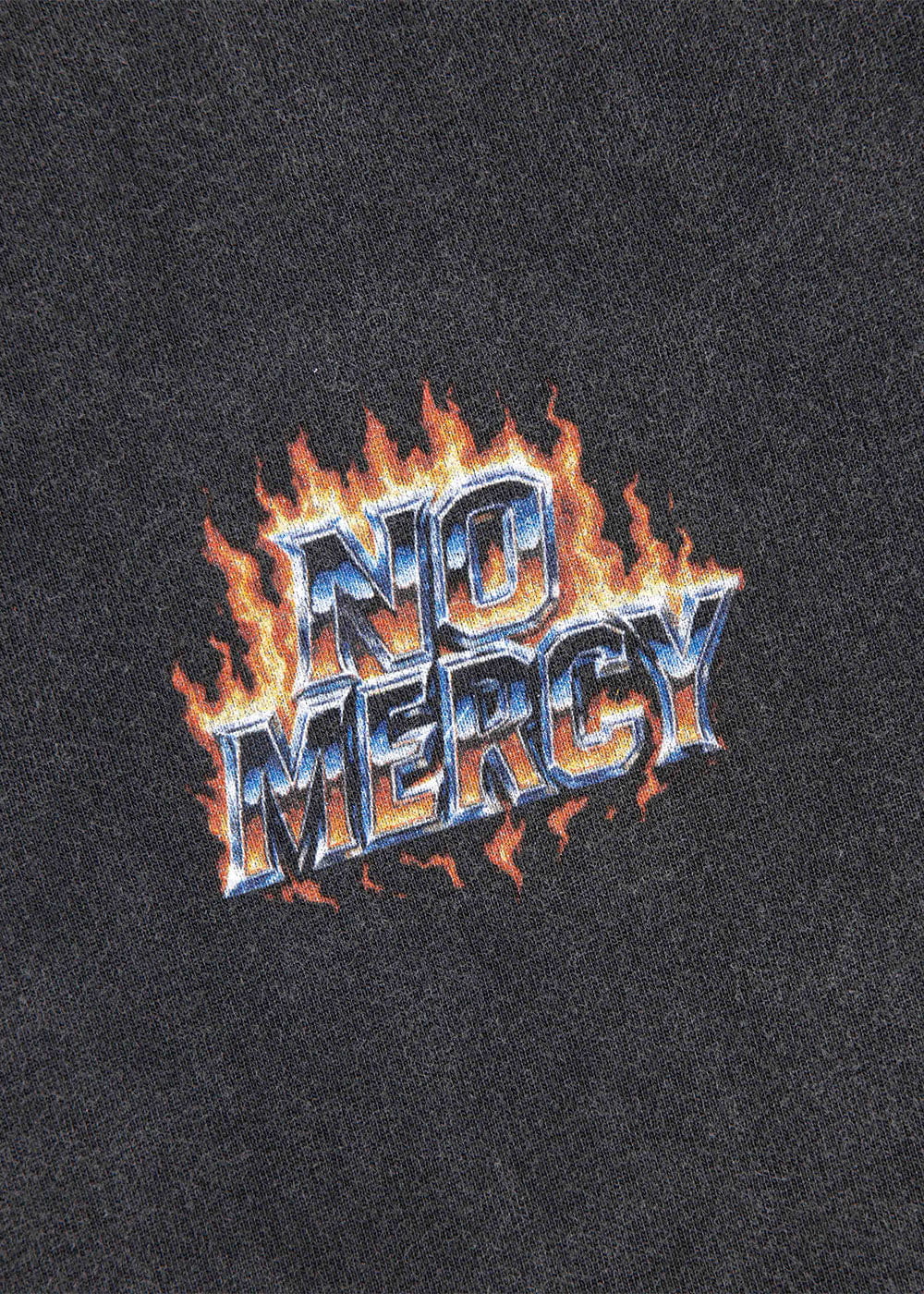 Close-up of black knit fabric with metallic blue and white NO MERCY lettering surrounded by orange flames.