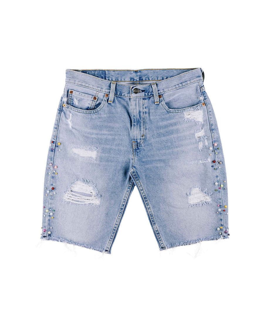 Light blue distressed denim Bermuda shorts with frayed hems and multicolored beads along the side seams on white.