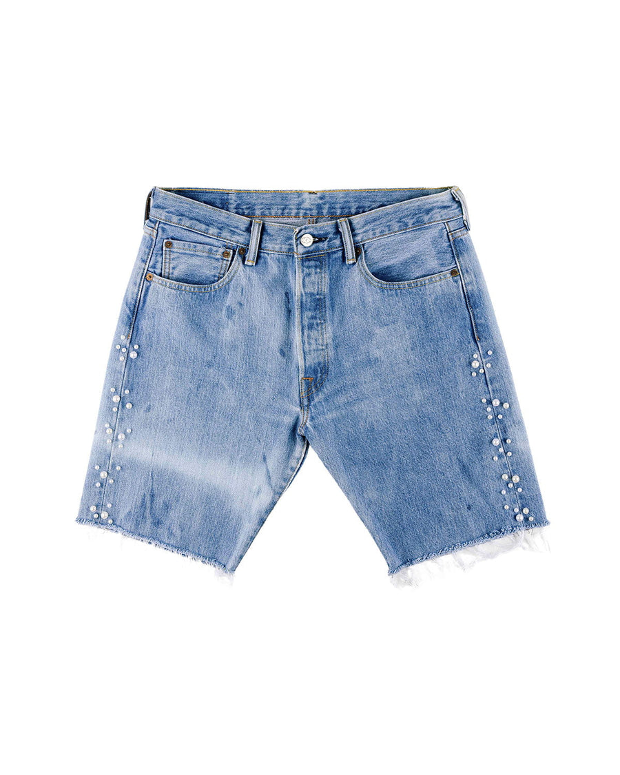 Light blue denim shorts with pearl-like side embellishments, frayed hems, front pockets, and belt loops on white.