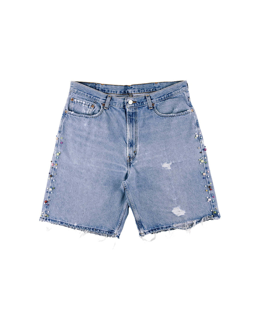 Light blue denim shorts with frayed hems, distressed patches, and multicolored beads along the sides on a white background.