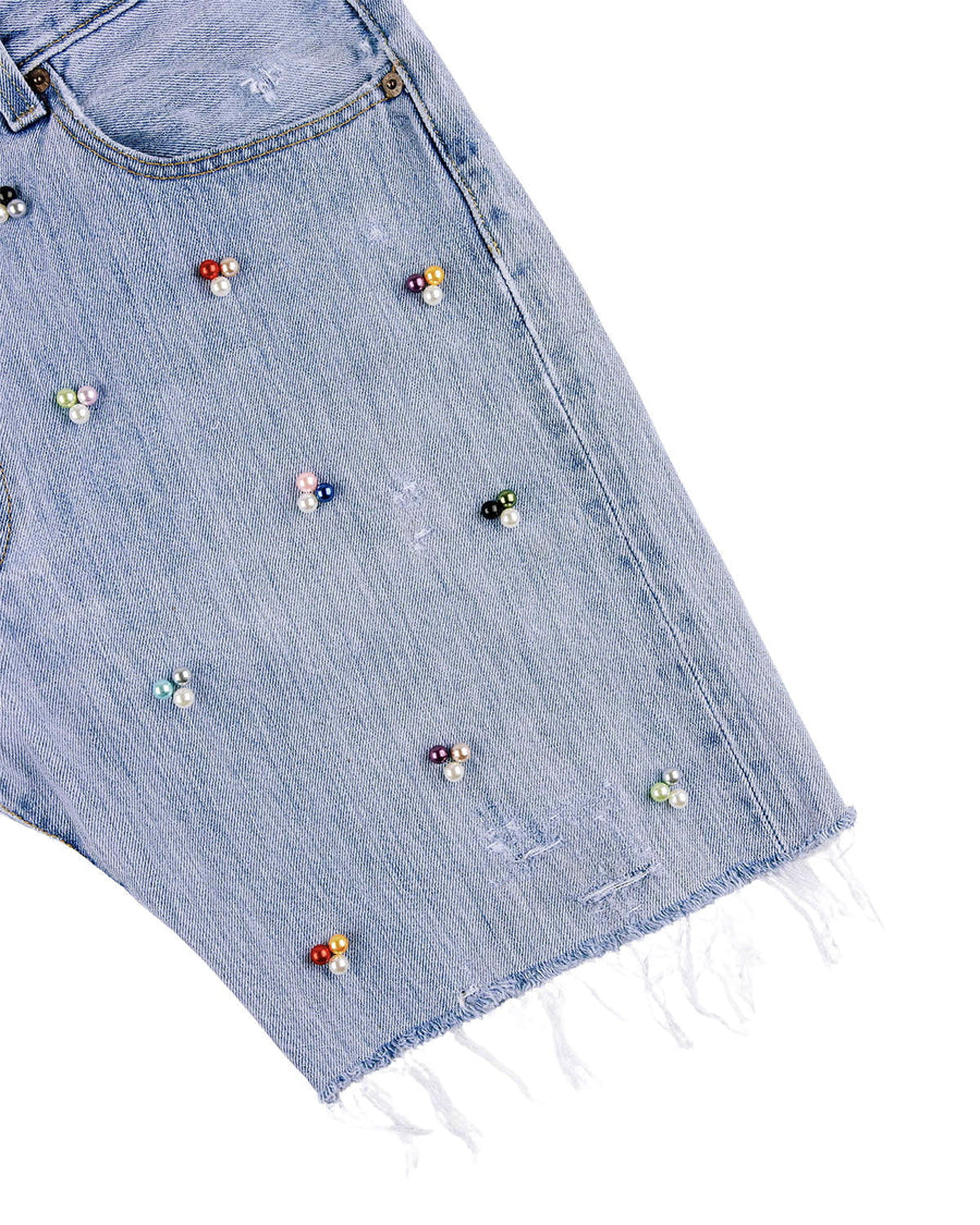 Light blue denim shorts with multicolored pearl-like beads, distressed details, and a frayed hem on a white background.
