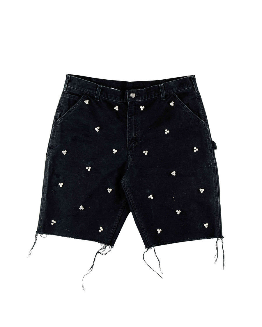 Black denim shorts with pearl-like bead clusters, slanted pockets, belt loops, and frayed hems on a white background.