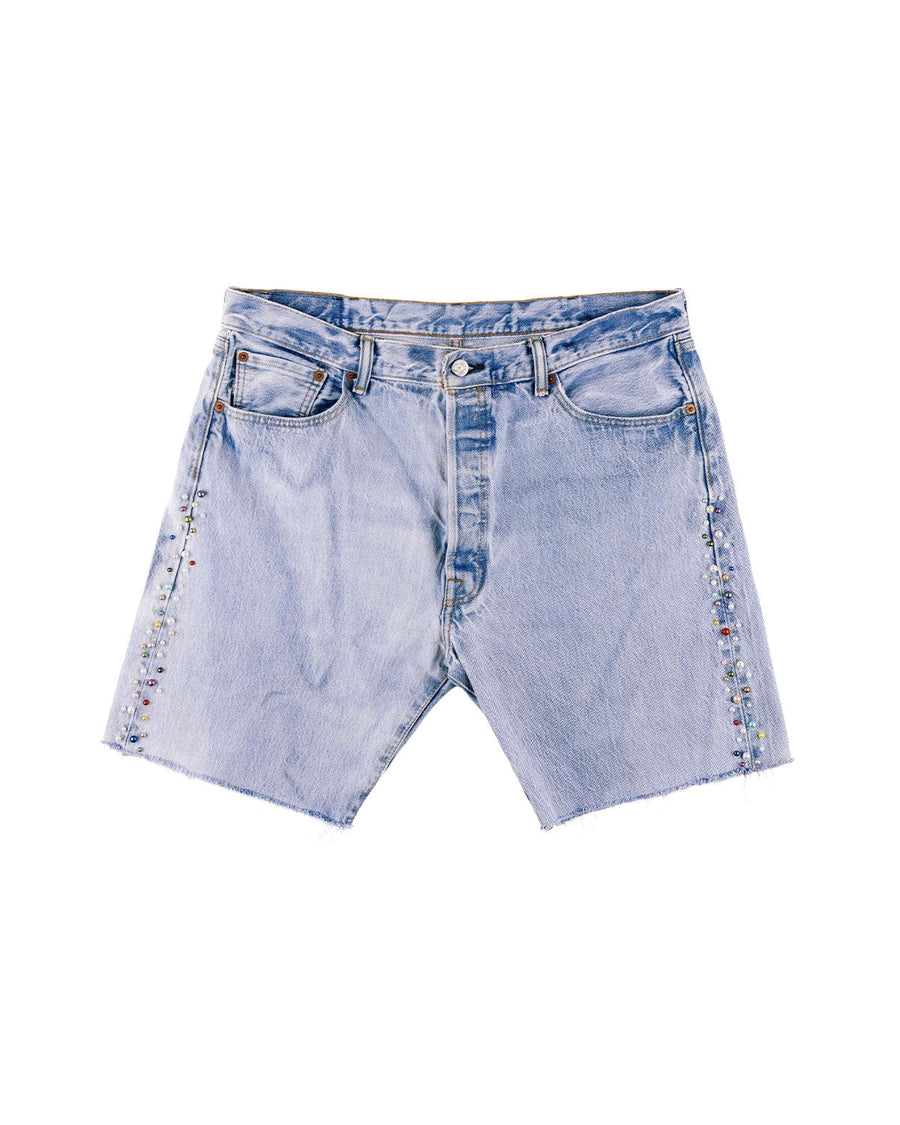 Light blue denim shorts with raw hems, front pockets, and multicolored bead embellishments along the sides on white.