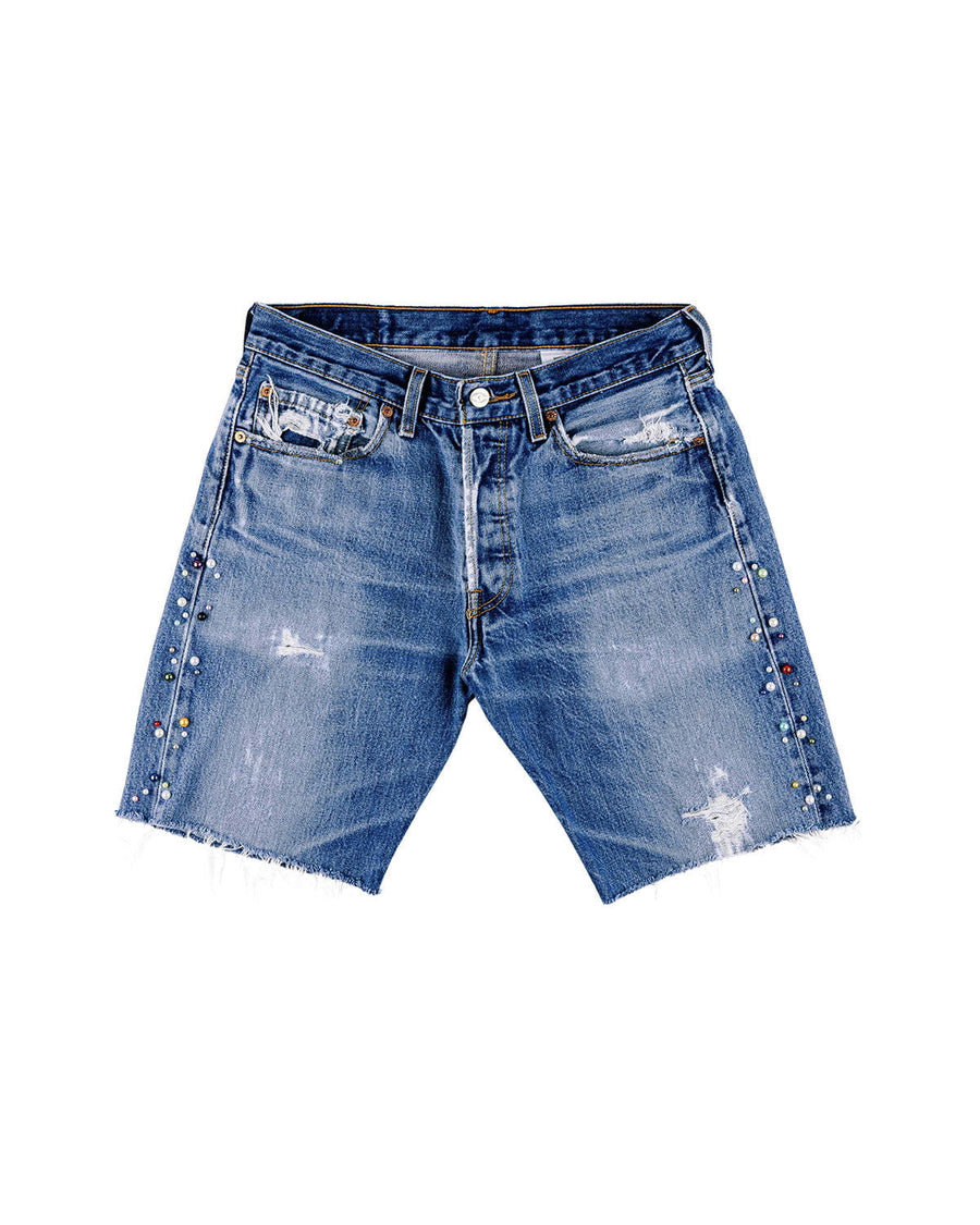 Blue denim shorts with distressed patches, frayed hems, and multicolored bead embellishments on a white background.